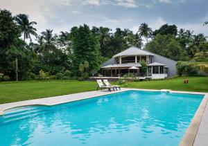 a swimming pool in front of a house at LohonoStays Villa Lani in Alībāg