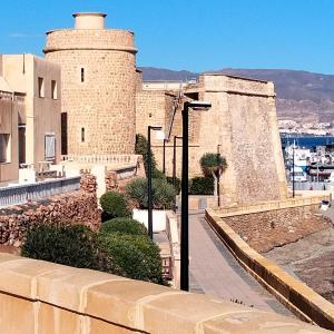 a building with a tower and a street light at Roquetas "Estudio acogedor cerca del Castillo y del puerto de Roquetas, aireconditionado" in Roquetas de Mar