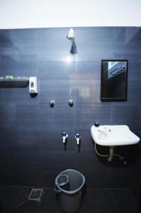 a bathroom with a sink and a toilet and a tv at La Ruelle Guest House in Pondicherry