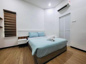 a bedroom with a large bed with blue sheets at Spacious Home in the Heart of Melaka for Families 10 pax, Chill & Relax at Extra Wide Balcony, COMFY HILL in Malacca