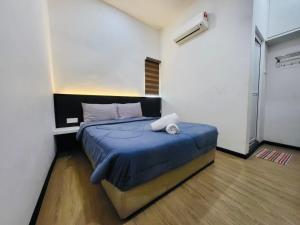 a bedroom with a bed with a blue comforter at Spacious Home in the Heart of Melaka for Families 10 pax, Chill & Relax at Extra Wide Balcony, COMFY HILL in Malacca
