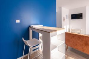 a desk in a room with a blue wall at La perle de Montargis - Charmant T2 in Montargis
