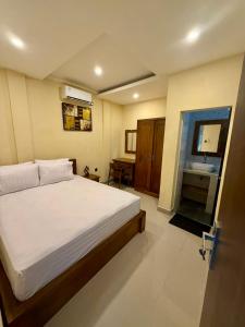 a bedroom with a large bed and a bathroom at Alena in Nusa Dua