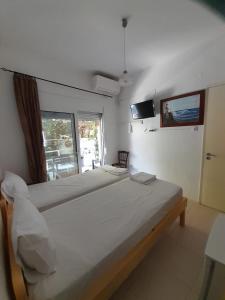 a bedroom with a large bed and a window at Iliada Skiathos rooms in Skiathos