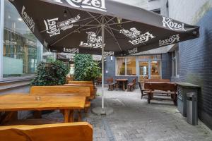 a restaurant with wooden tables and an umbrella at Hotel Stadion in Kielce