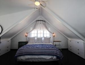 a attic bedroom with a bed and a window at Majestic Secret in Cape Town