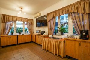 a large kitchen with wooden cabinets and windows at Hotel Stadion in Kielce