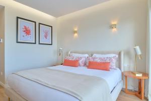 a bedroom with a large white bed with orange pillows at Hotel de Ilhavo Plaza & Spa in Ílhavo +138 photos