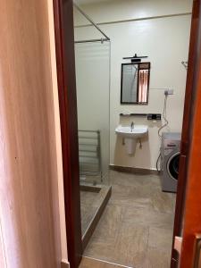 a bathroom with a sink and a glass shower door at Ibis Stays in Naziba +10 photos