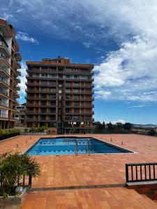 a swimming pool in front of a large building at Ibis Stays in Naziba
