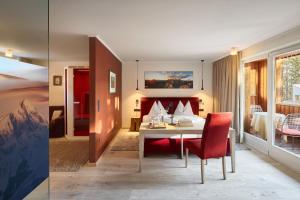 a hotel room with a bed and a table and chairs at Dolomit Boutique Hotel in La Villa
