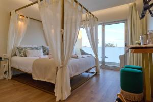 a bedroom with a canopy bed with a view of the ocean at Hotel de Ilhavo Plaza & Spa in Ílhavo