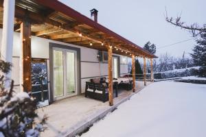 a house with a covered patio in the snow at Greis Home in Maliq
