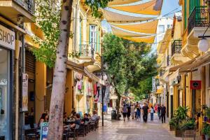 a group of people walking down a street with buildings at Limassol center Soul in Limassol