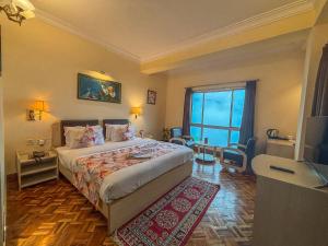 a hotel room with a bed and a large window at Rare Himalayas De Regency Pelling in Pelling +64 photos