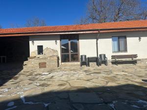 a building with two chairs and a bench in front of it at Han Gozdeika in Gozdeyka