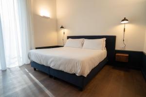 a bedroom with a large bed with white sheets at Maison Petronilla in Naples