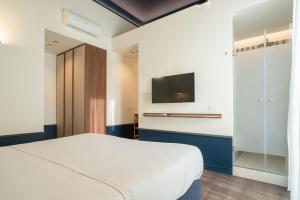 a bedroom with a bed and a flat screen tv at Maison Petronilla in Naples