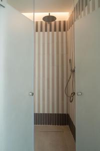 a shower with a glass door in a bathroom at Maison Petronilla in Naples