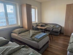 a room with three beds and a table in it at Ubytovanie Nitra in Nitra