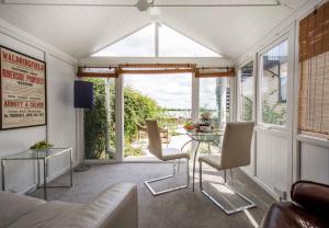 a living room with a glass table and chairs at Quayside Cottage in Waldringfield