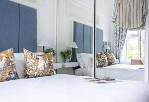a bedroom with two beds and a mirror at Quayside Cottage in Waldringfield