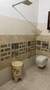 a bathroom with a toilet and a sink and a window at Little Haven Haveli - Luxury Heritage Homestay in Bikaner