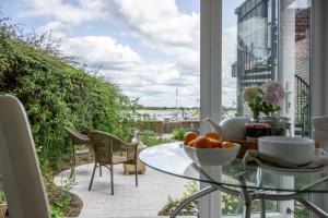 a balcony with a table and a view of the water at Quayside Cottage in Waldringfield