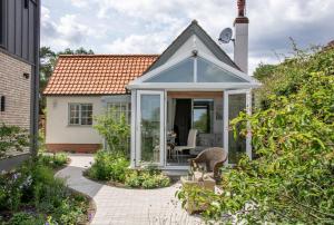 a small cottage with a conservatory in a garden at Quayside Cottage in Waldringfield
