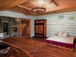 a room with a wooden table and a fireplace at Domik v gorakh in Bukovets