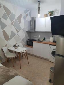 a kitchen with a small table and a kitchen with white cabinets at Galatia Studio in Thérissos