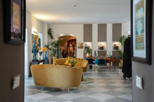 a lobby with a yellow couch and a table at Grand Hotel Alassio Beach & Spa Resort - The Leading Hotels of the World in Alassio +134 photos