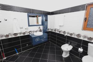 a bathroom with a toilet and a sink at Greis Home in Maliq +27 photos
