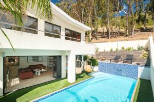 a house with a swimming pool in front of a house at Song of Ascent in Cape Town