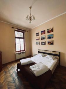 a bedroom with a bed with white sheets and a window at New York Hostel in Lviv