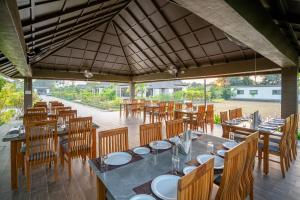 a dining room with tables and chairs and a roof at Daksh The Nirvana Retreat in Vitoj