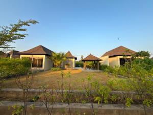 a house with two gazebos in a yard at Daksh The Nirvana Retreat in Vitoj