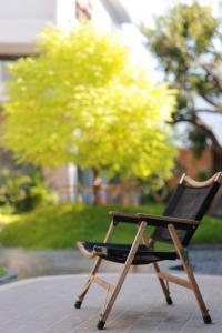 a wooden chair sitting on a sidewalk in front of a tree at Migoo Chiang Mai in Chiang Mai +48 photos