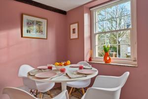 a dining room with a white table and white chairs at Finest Retreats - Meadowsweet Cottage in Wingfield