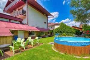 a yard with a pool and chairs and a house at Ada in Muszyna