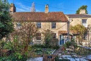 an old stone house with a garden in front of it at Finest Retreats - Meadowsweet Cottage in Wingfield