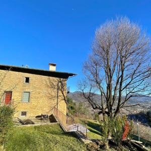 a brick building with a staircase next to a tree at Foresteria Antica Bastia B&B in Bergamo +43 photos