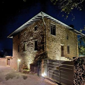 an old brick building with a gate at night at Foresteria Antica Bastia B&B in Bergamo