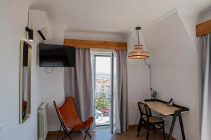 a living room with a table and chairs and a window at WOT Ericeira in Ericeira