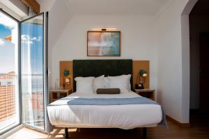 a bedroom with a bed and a large window at WOT Ericeira in Ericeira