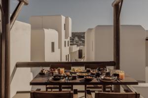 a table with food on top of a balcony at ananea Mykonos - Adults Only in Ornos