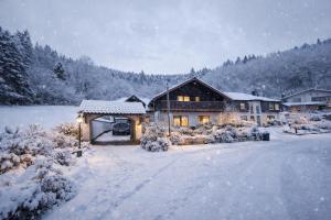 a house in the snow with lights on at GreenHell Stays Müsch - Nürburgring in Müsch