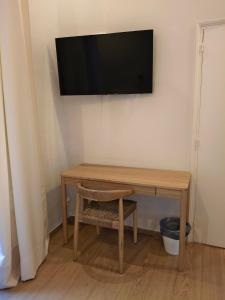 a wooden table with a television on a wall at Casa Consell Bailen, Guest House in Barcelona