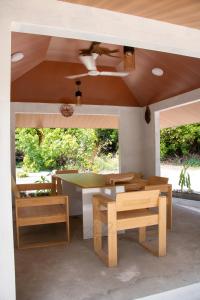 a room with a table and benches and a ceiling at Coral stone in Bileffahi +18 photos