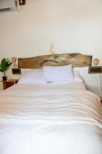 a white bed with a wooden headboard in a bedroom at Coral stone in Bileffahi